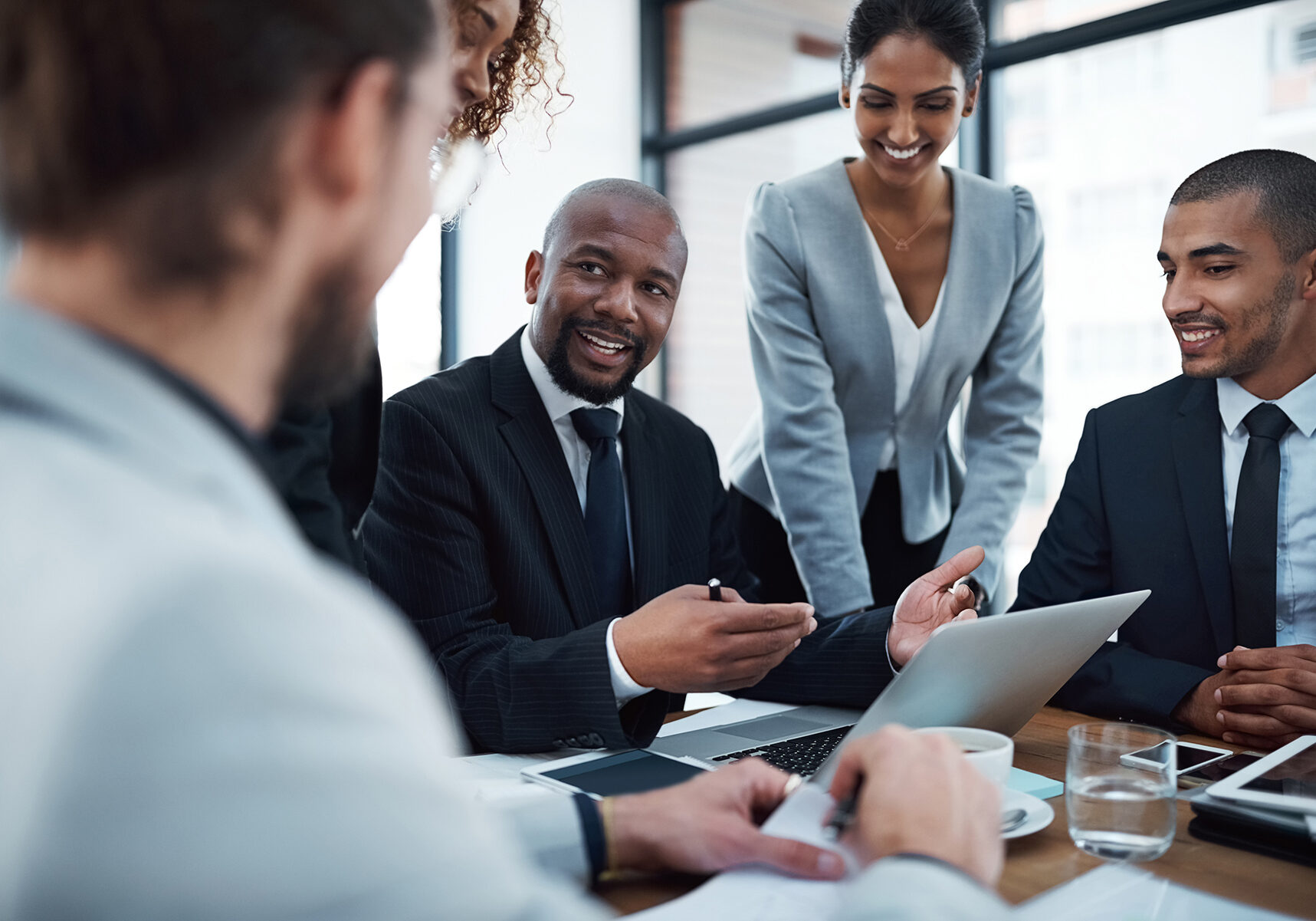 Shot of a group of businesspeople discussing something on a laptop