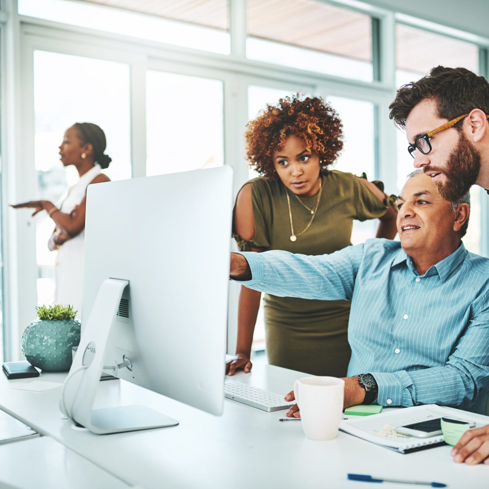 Shot of a group of businesspeople working together on a computer in an office